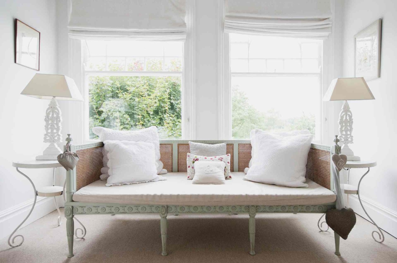 Roman shades on windows in a shabby chic living room with a sofa and two end tables at Window Decor of Fairfax near Fairfax, VA